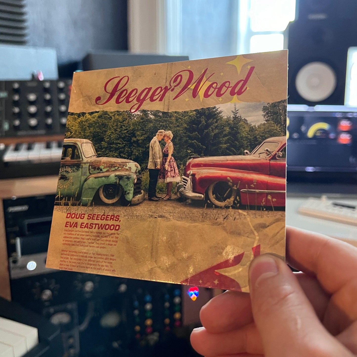 Holding the pchysical seegerwood CD in music studio